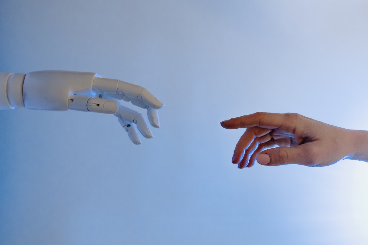 Eine Roboterhand und eine menschliche Hand, die versuchen, sich gegenseitig zu berühren
